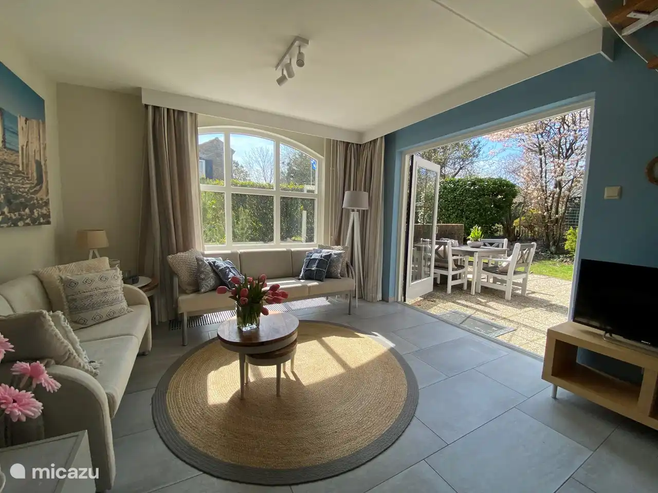 The tastefully decorated living room is wonderfully sunny and has French doors to the terrace.