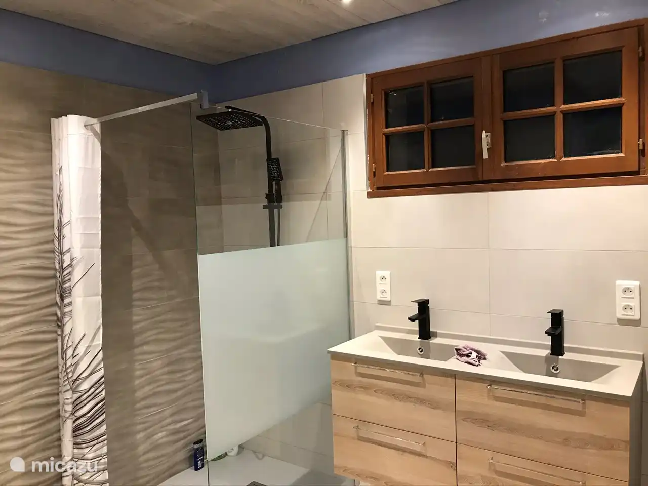 The bathroom has a walk-in shower and two sinks.