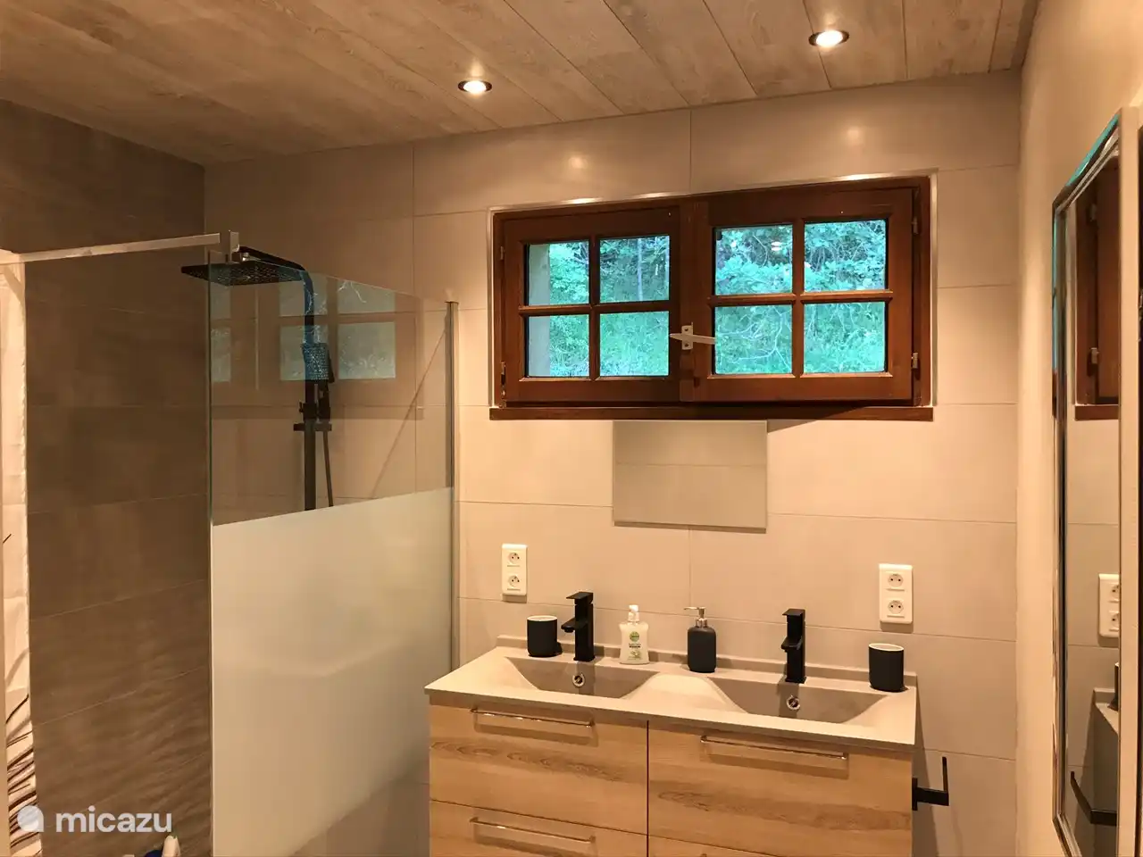 The bathroom has a walk-in shower and 2 sinks