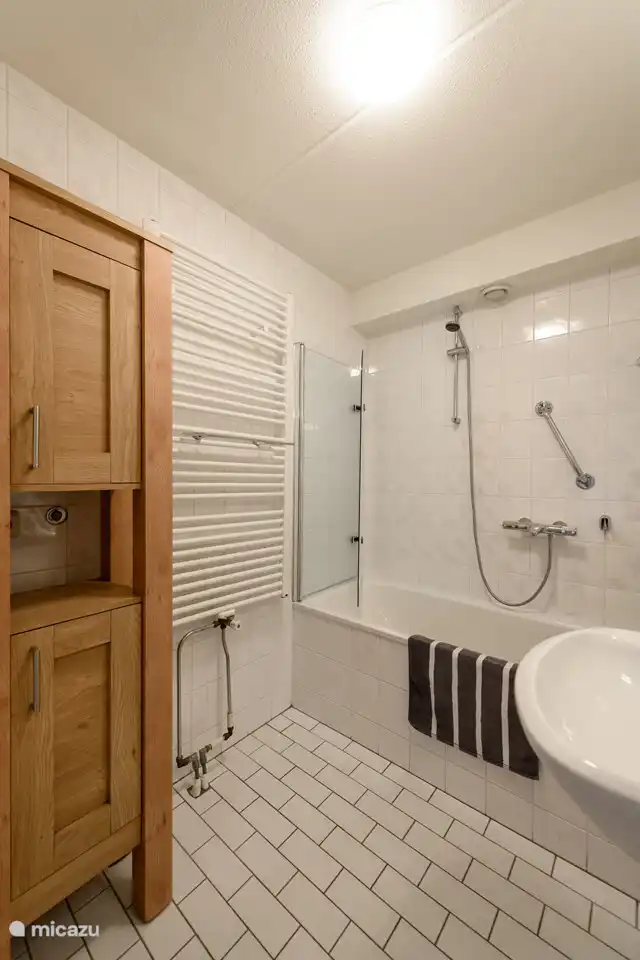 Das frische Badezimmer hat eine Badewanne und Dusche.