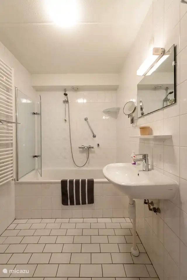 Das frische Badezimmer hat eine Badewanne und Dusche.