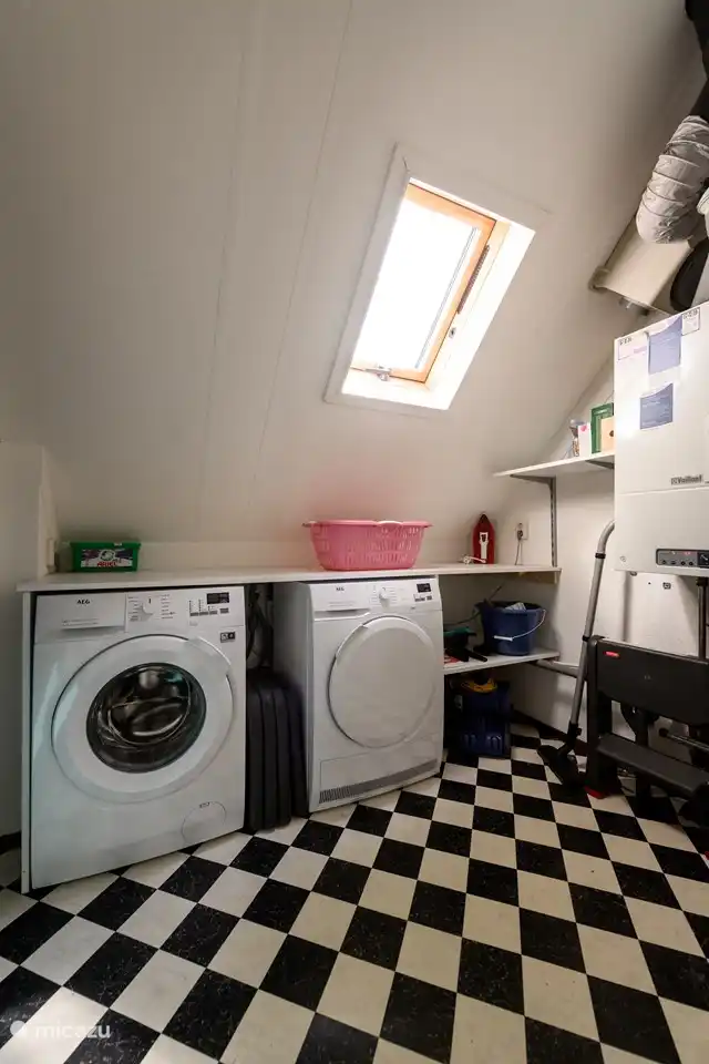 Eine Waschmaschine und ein Kondenstrockner stehen im Hauswirtschaftsraum zur Verfügung.