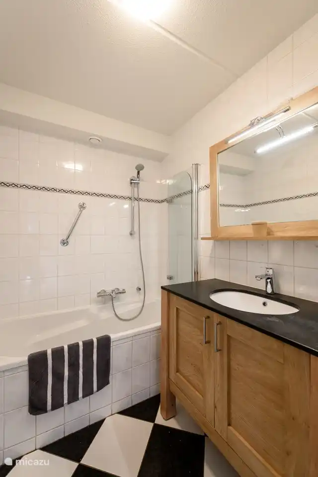 El cuarto de baño fresco tiene un tocador, bañera y ducha.