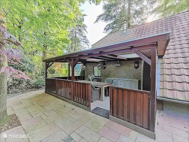 Maison de vacances Louise | Pays-Bas, Gueldre, Lunteren - bungalow La terrasse couverte est équipée d'un radiateur et d'une grande table avec des fauteuils confortables.