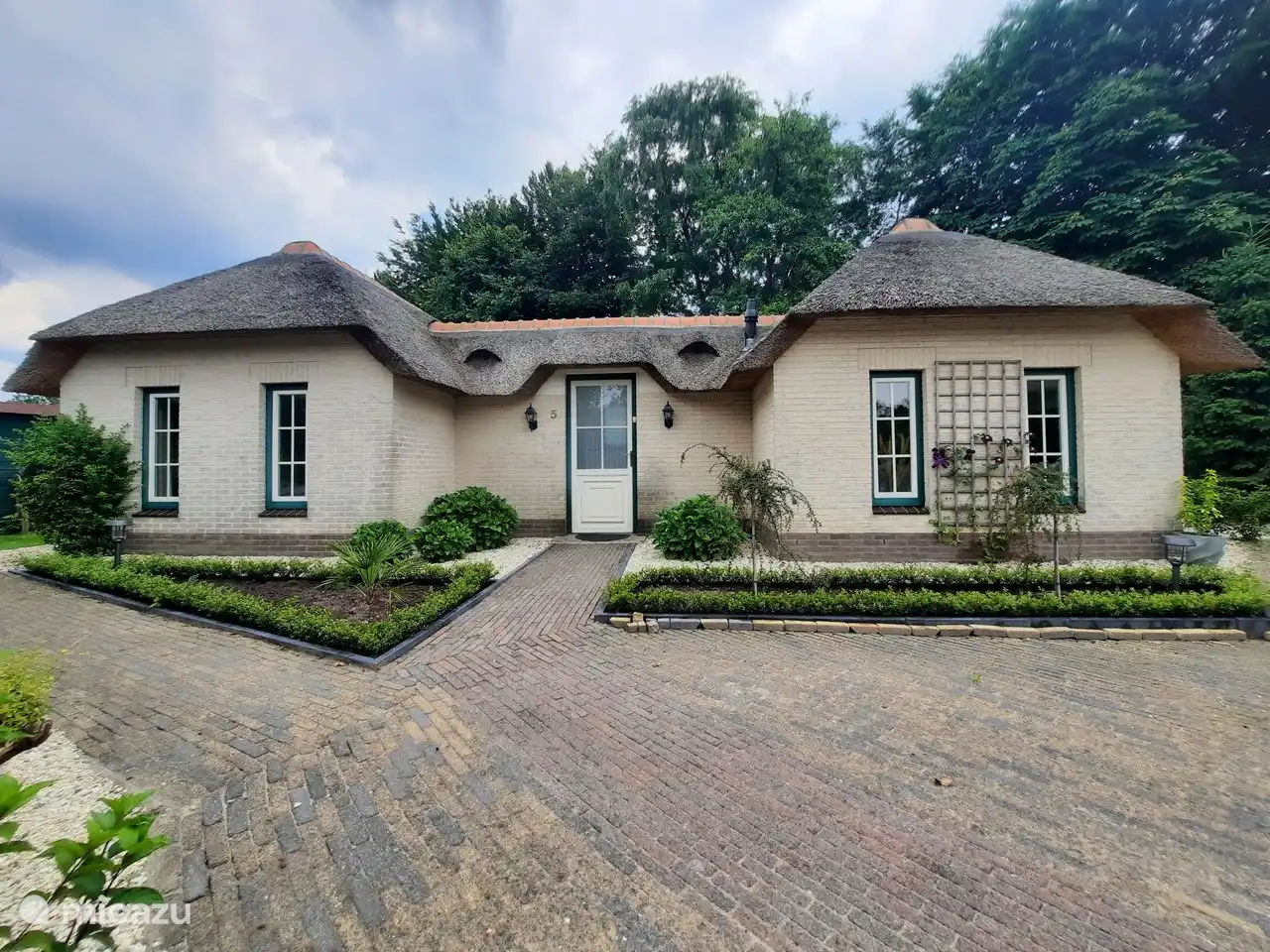 This is the front of the house visible from the gate. To the left of the photo is the sleeping area of the house with 2 bedrooms and a bathroom with shower. On the right side of the house is the living area with a living room and open kitchen.