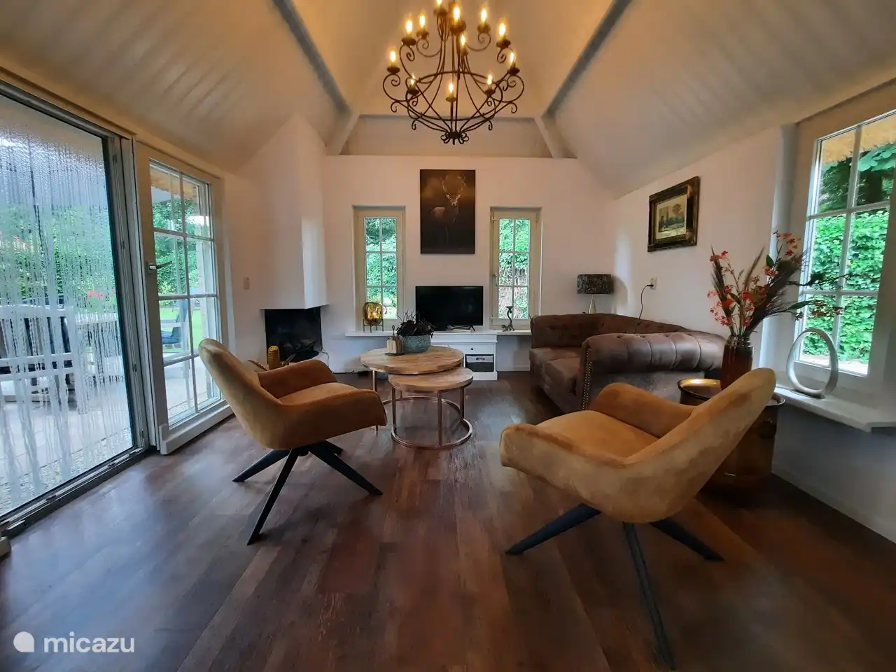 The living room has a luxurious warm appearance with an open construction. TV is a smart TV with Netflix