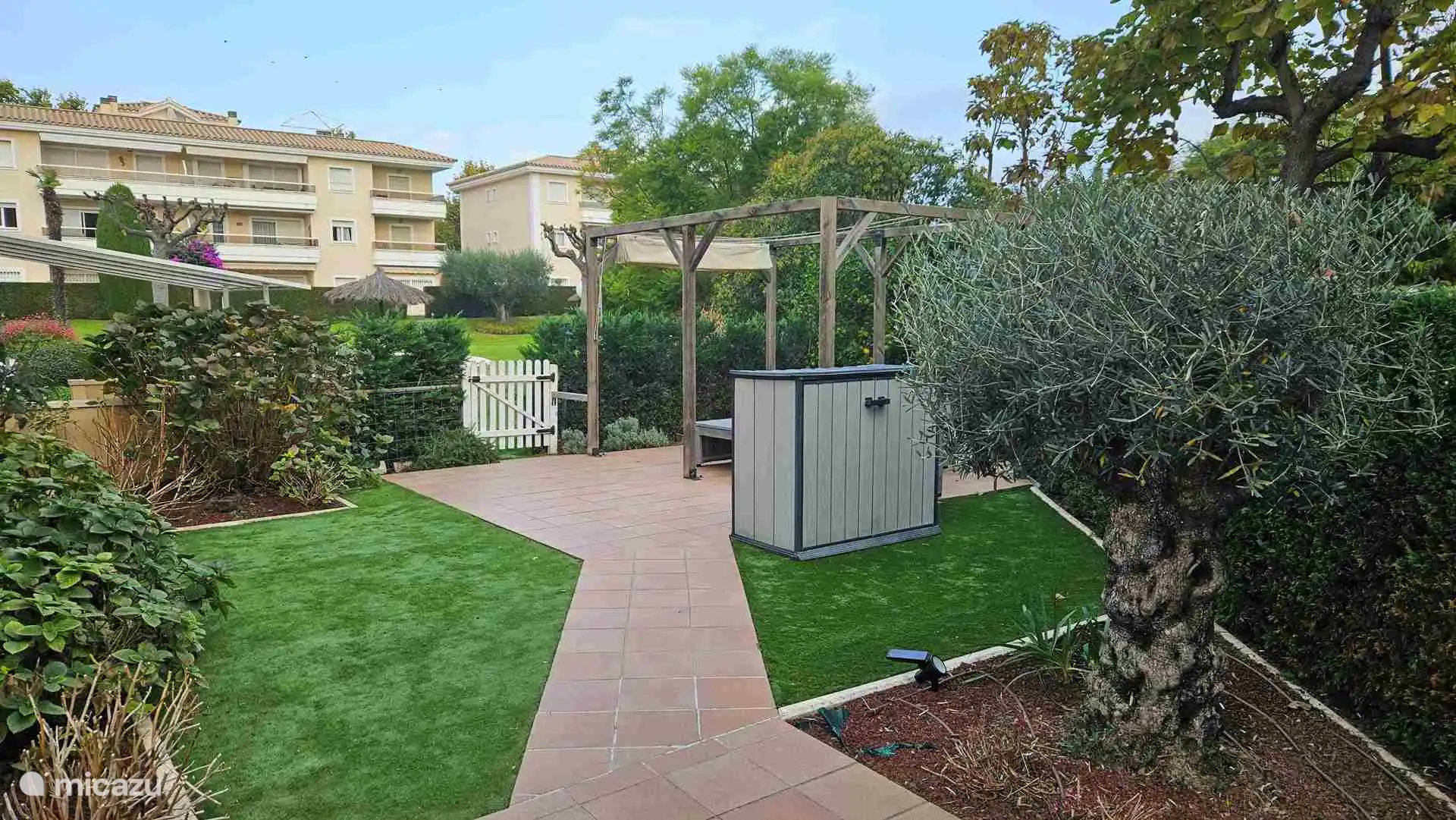 Notre jardin ensoleillé avec accès direct à la piscine commune.