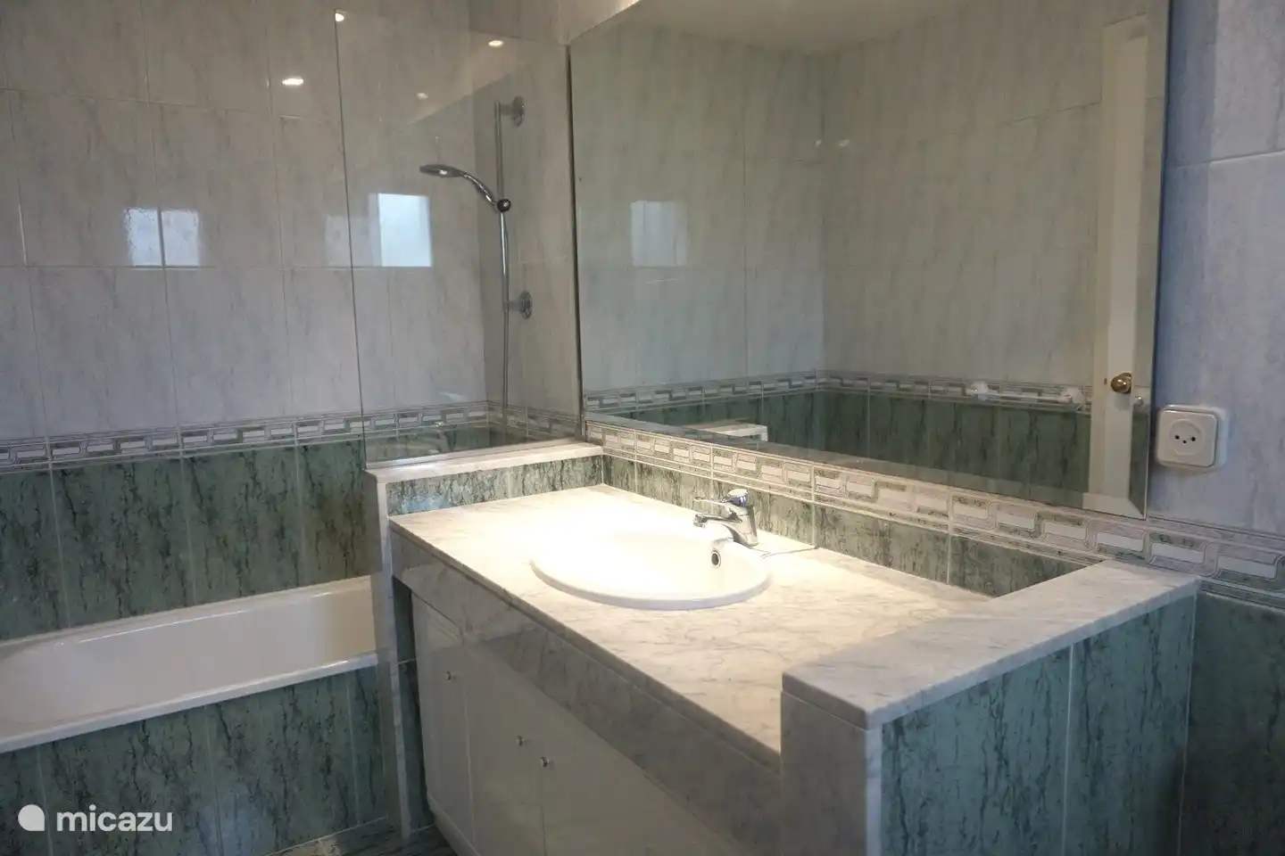 Salle de bain avec lavabo, WC, bidet et douche avec baignoire.
