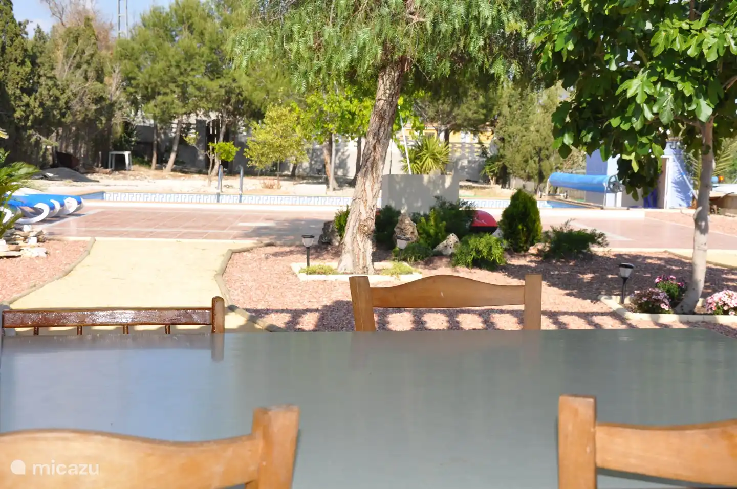 Lekker genieten in de schaduw van de porche (terrasoverkapping). Hier staat een eettafel met 10 zitplaatsen.
