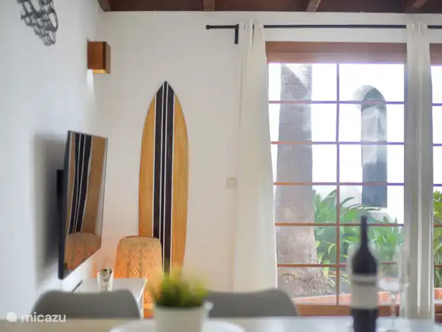 bungaló en España, Fuerteventura, Corralejo – Brisa del Mar Fuerteventura Sala de estar con puerta corredera donde se puede subir las escaleras a la azotea por la parte trasera de la casa