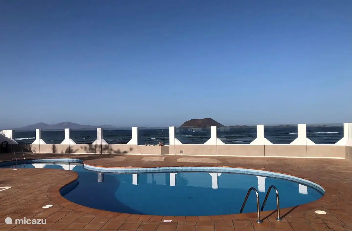 Der Pool befindet sich am Strand mit Blick auf die Insel Lobos und Lanzerote.