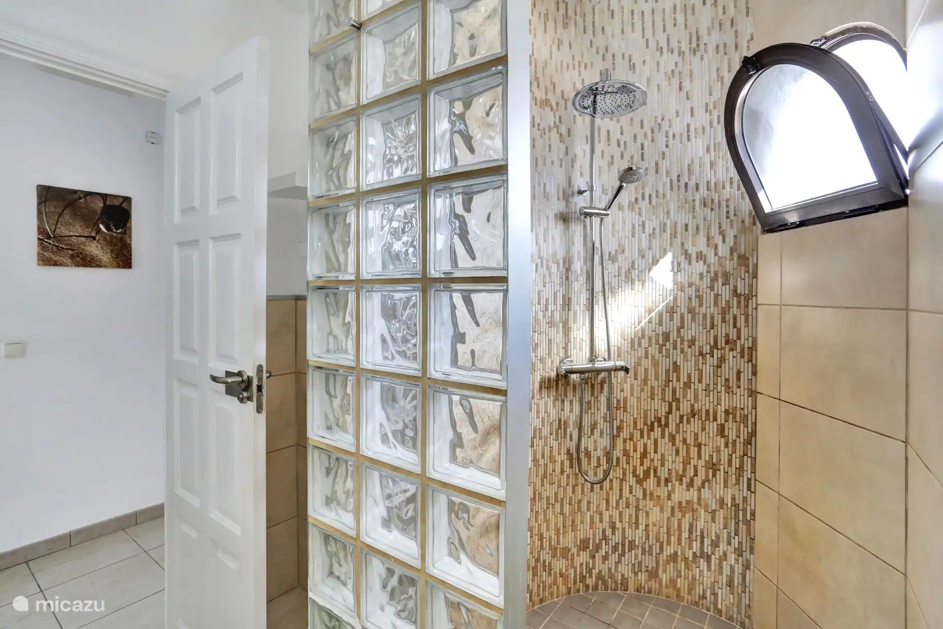 Das Badezimmer verfügt über eine geräumige Dusche, Waschbecken und Toilette.