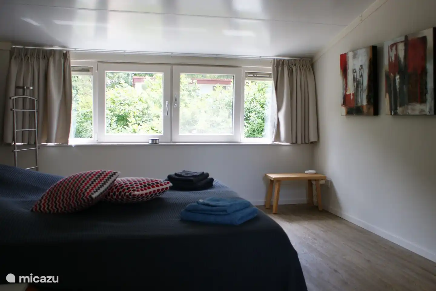 Auch vom Schlafzimmer im Obergeschoss hat man einen schönen Blick ins Grüne.
Lesen Sie gerne im Bett? Das ist möglich, denn im Schlafzimmer im Obergeschoss wurden praktische Auping-Leuchten installiert.
Und lassen Sie sich vom Raumgefühl durch die hohe Decke überraschen!