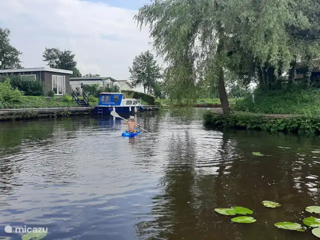 Hûske twa | Pays-Bas, Frise, Oudwoude - maison de vacances Au loin, on aperçoit le canal. Vous pouvez naviguer vers Kollum et Dokkum via cette eau. La photo montre aussi notre enfant de 8 ans sur le canot des enfants.