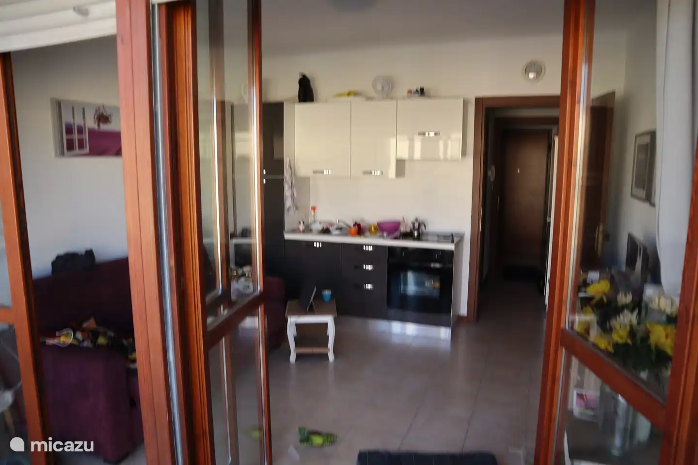 La sala de estar con la cocina abierta, vista desde el balcón.