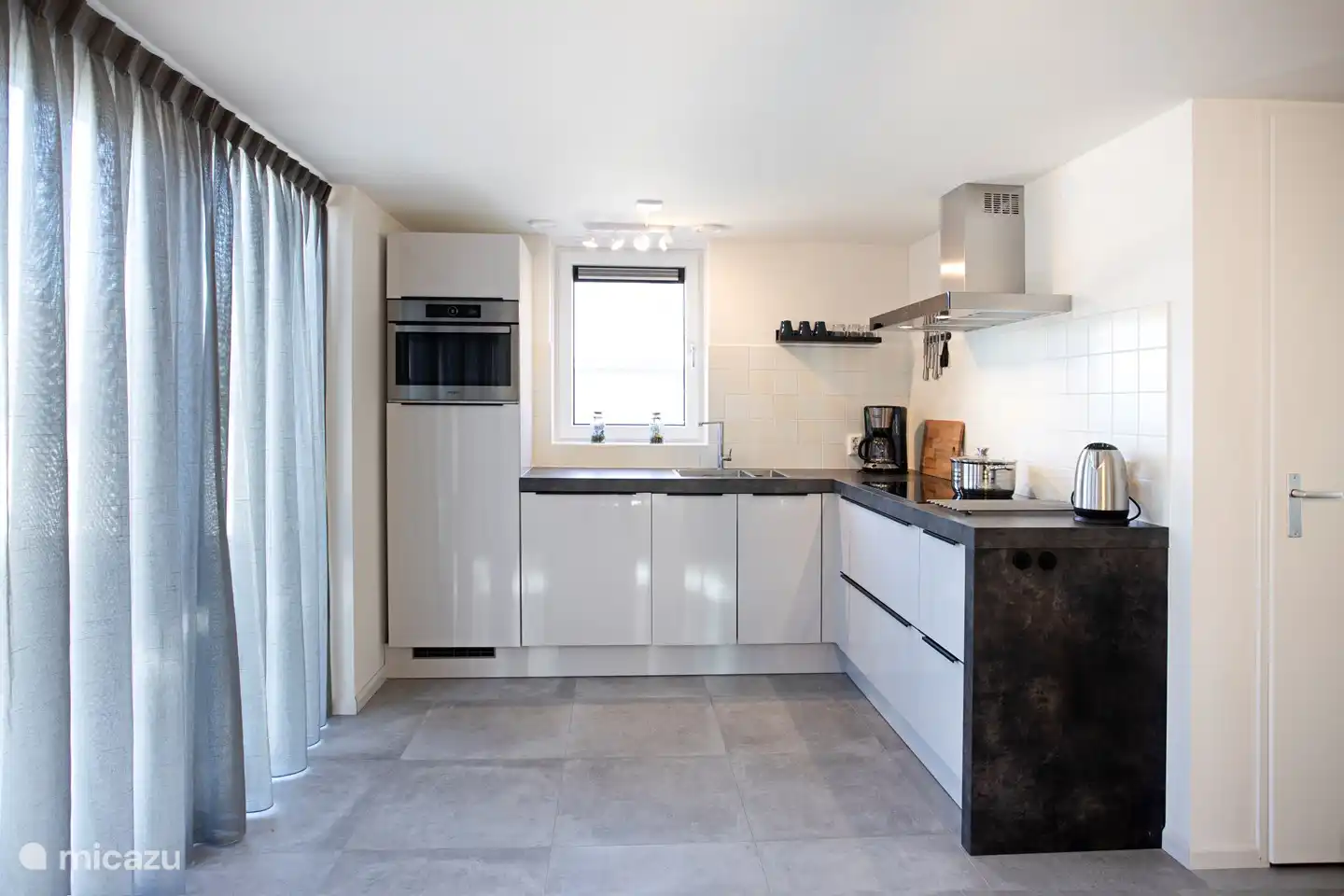 Luxurious kitchen with dishwasher, combination microwave, induction, large fridge with freezer and extractor hood.