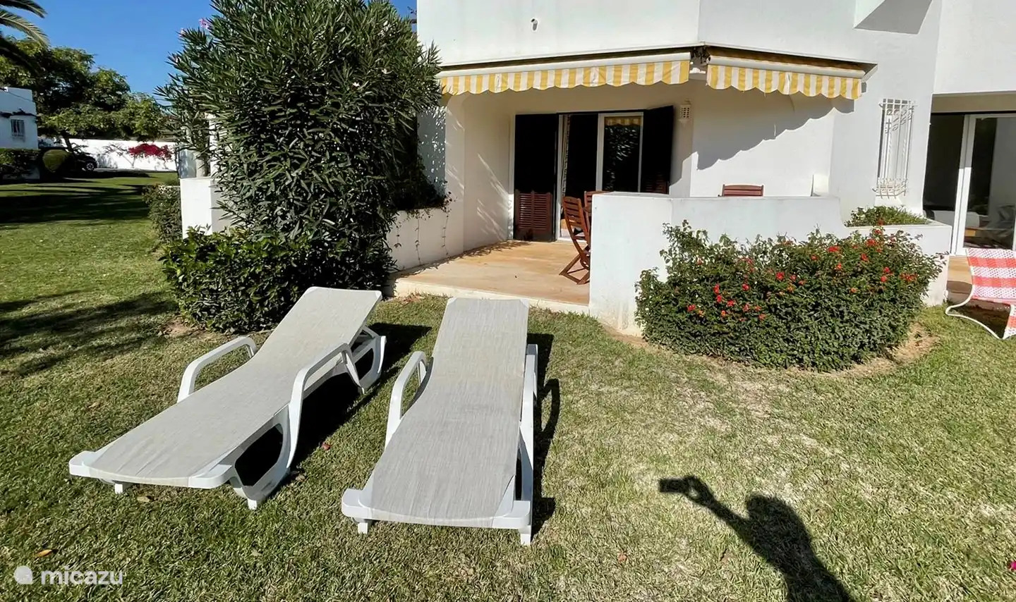 La terraza desde la sala de estar, las hermosas tumbonas y las vistas entran en un oasis de vegetación