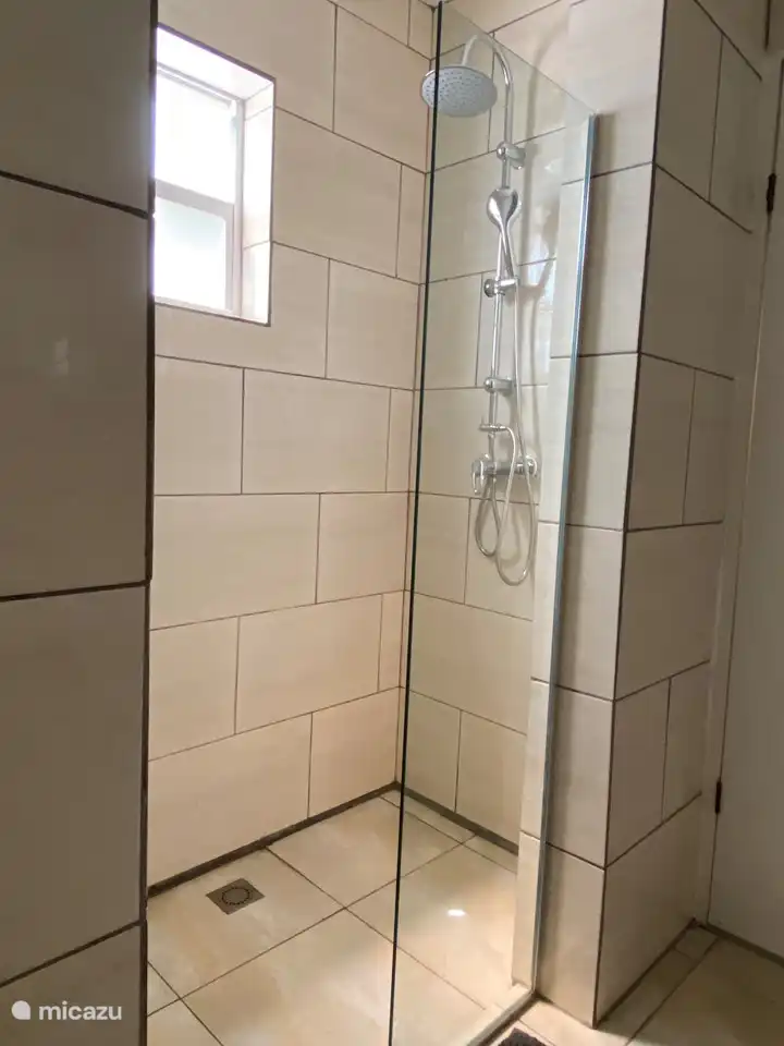 Adjoining bathroom to bedroom 2 & 3 with rain shower, sink, toilet and washing machine.