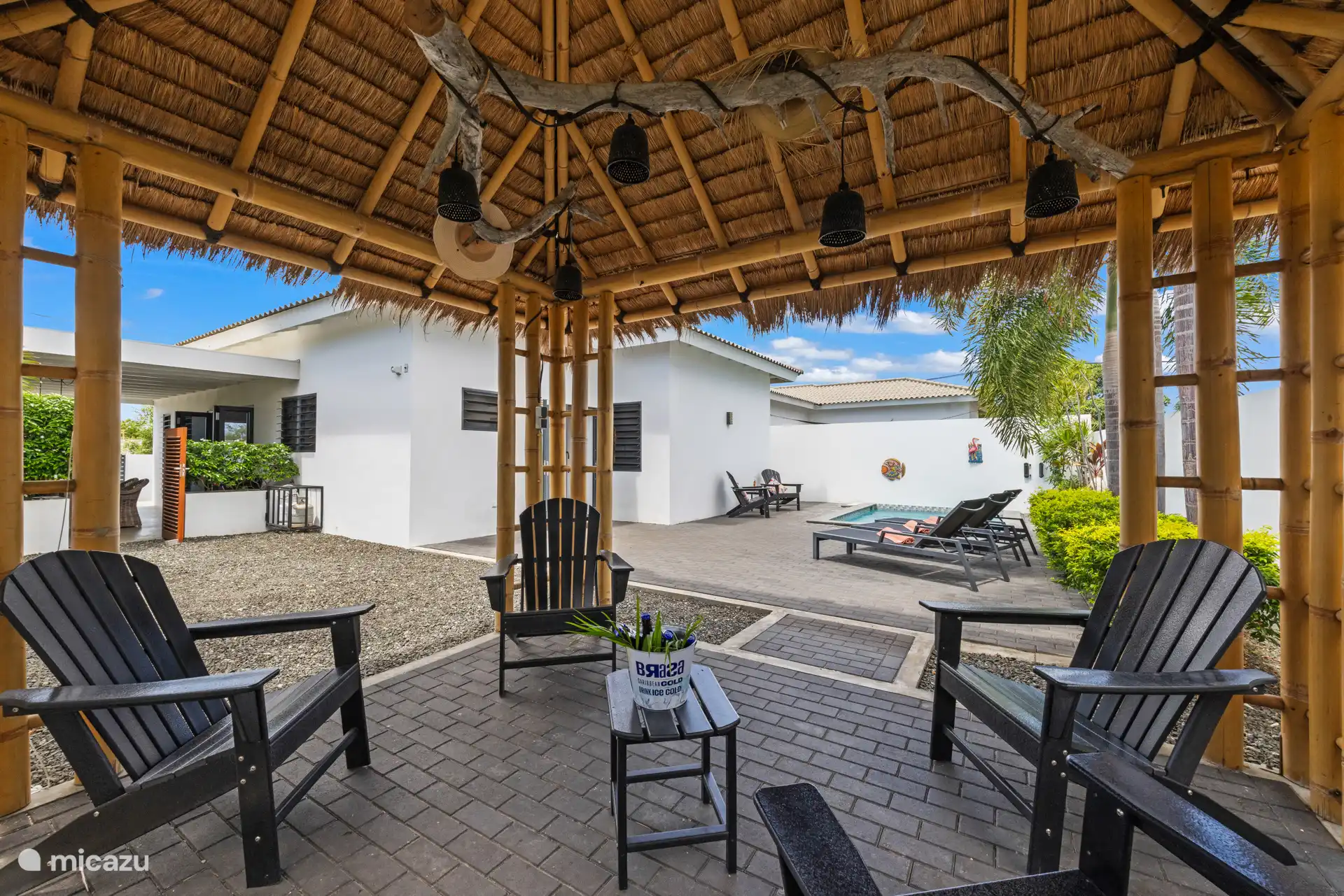 Garten mit schattigem Bereich unter der Palapa und dem Pool  