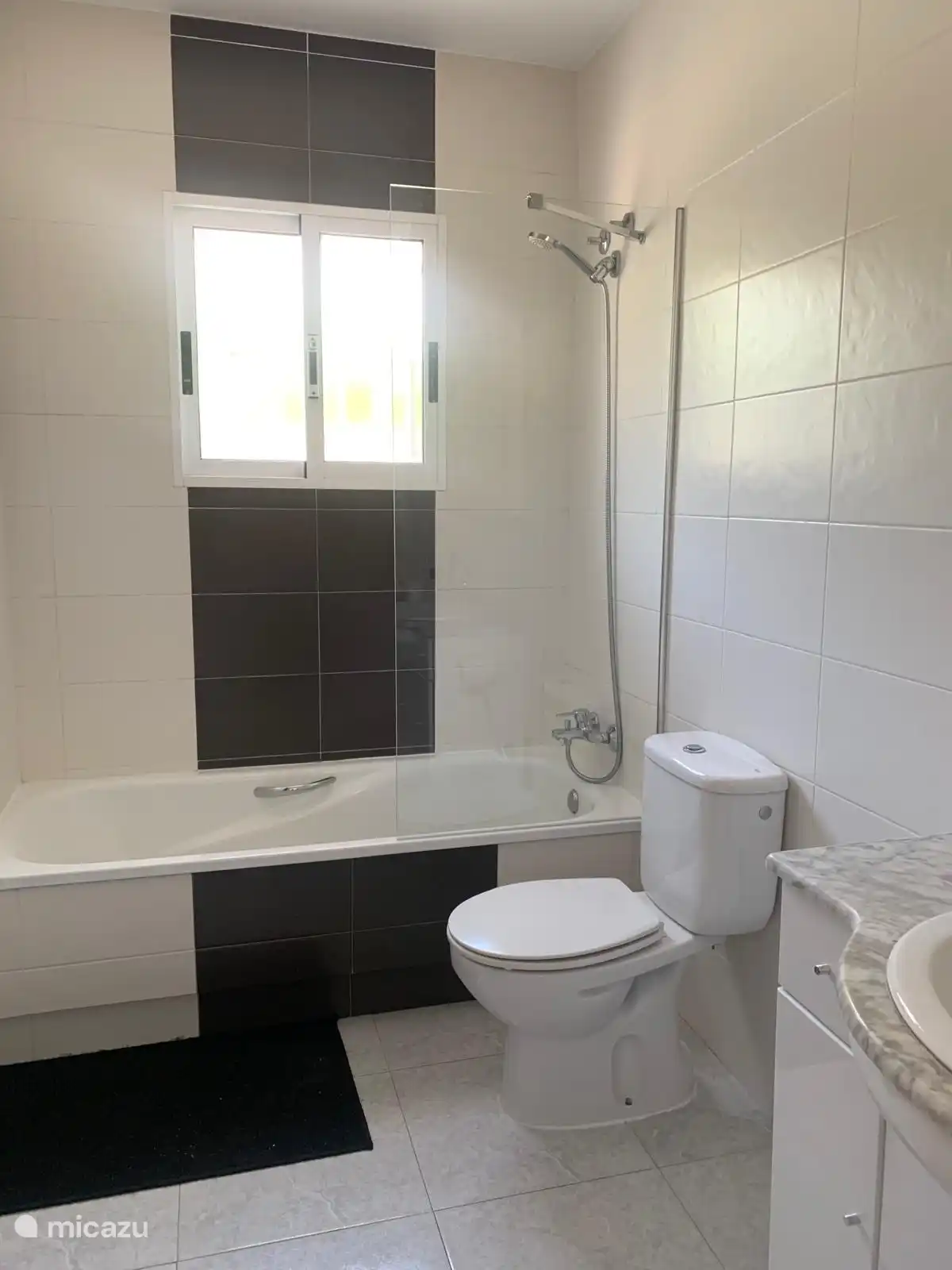 Baño moderno con bañera y muebles de baño con un toque español 