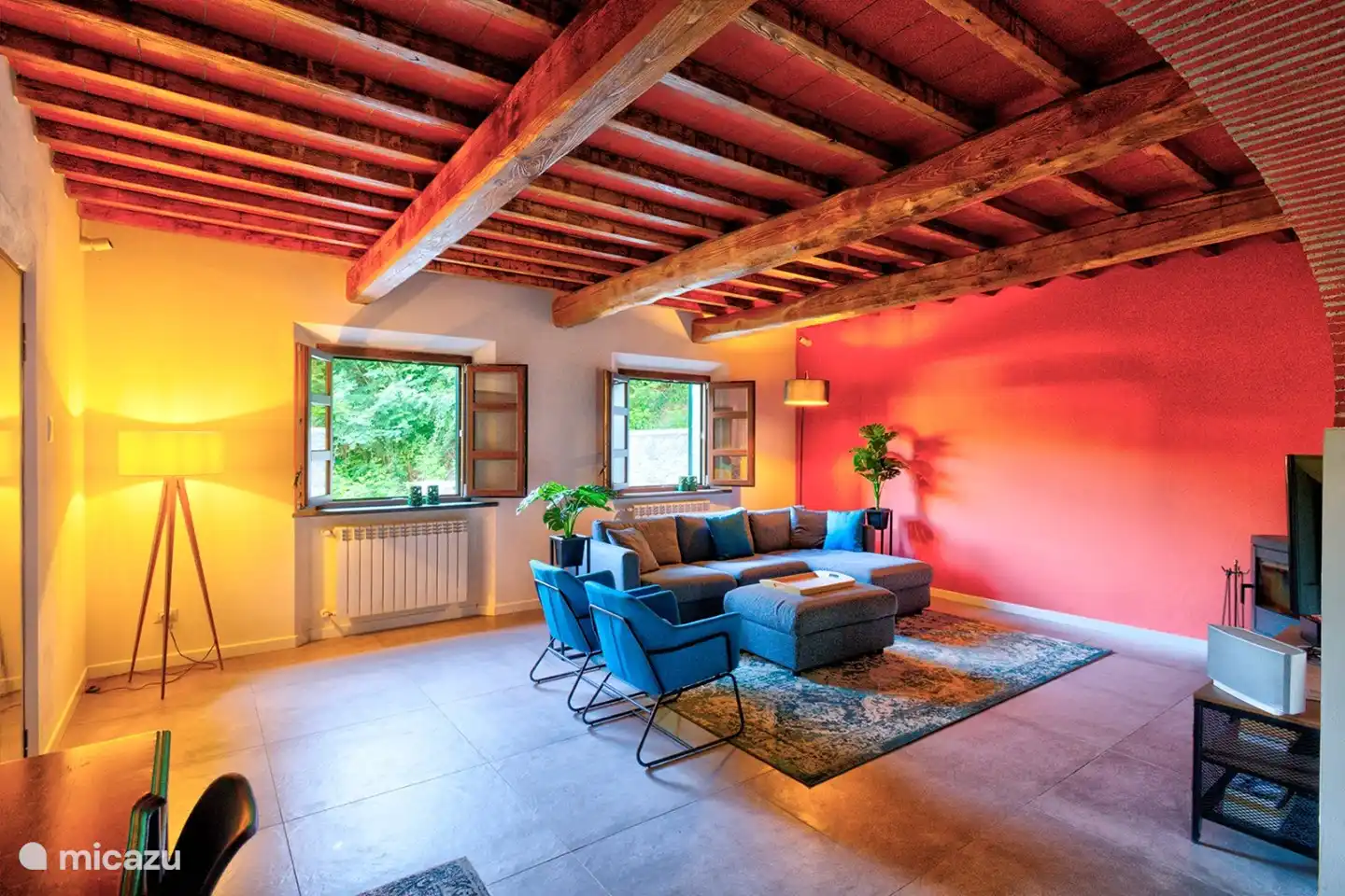 Das Wohnzimmer mit Holzofen und Flachbildfernseher