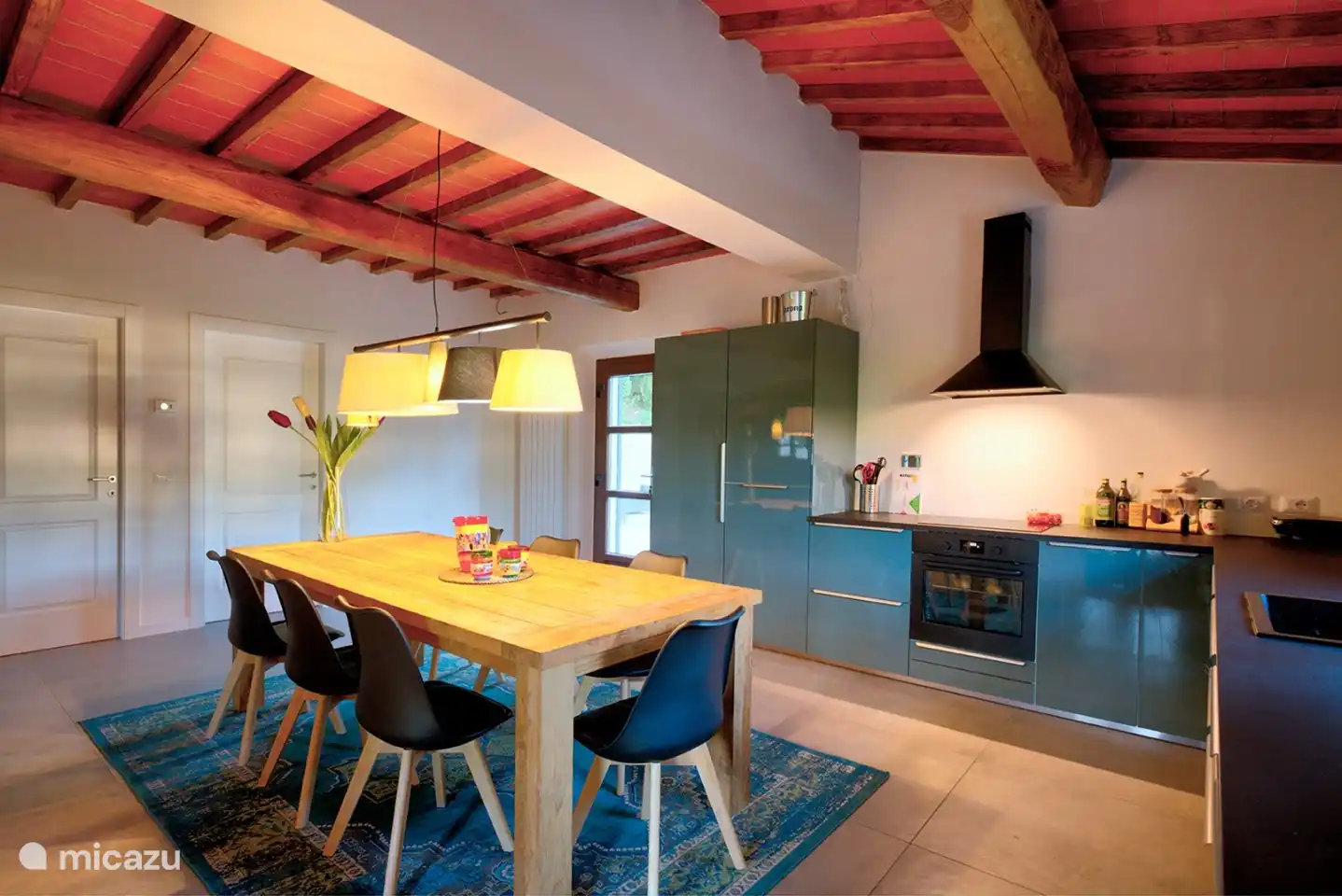 Die Küche ist ausgestattet mit einem großen Kühlschrank, Gefrierschrank, Esstisch, Umluftbackofen, Induktionskochfeld, Dunstabzugshaube und Spülmaschine