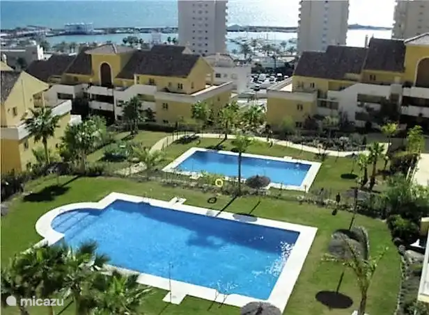 2 Schwimmbecken mit Sonnenbänken, Sonnenschirmen und einem Rettungsschwimmer