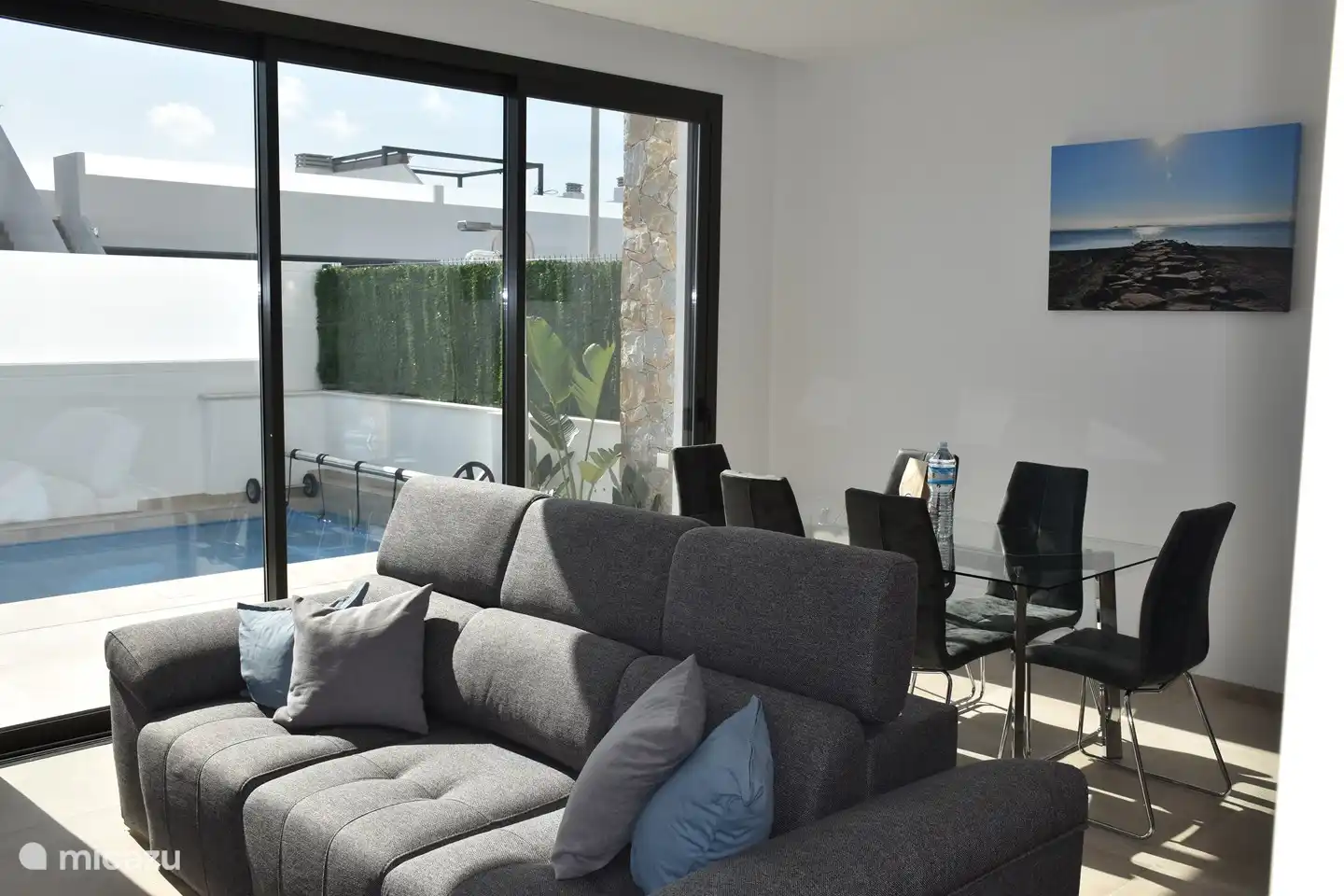 Der Blick von der offenen Küche/Wohnzimmer nach draußen. Kinder im Pool können von hier aus immer überwacht werden. Klimaanlage/Heizung ist in diesem Zimmer ebenfalls vorhanden.