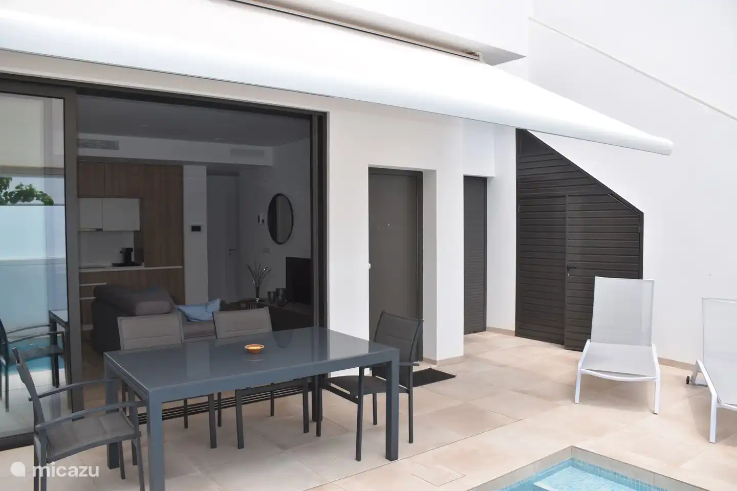 Sowohl auf der unteren Terrasse als auch auf der Dachterrasse ist ausreichend Platz für Sonnenliegen. Insgesamt stehen 6 Sonnenliegen zur Verfügung; Ein Gartentisch mit 6 Stühlen befindet sich sowohl im Erdgeschoss als auch im Obergeschoss. Auf Wunsch kann ein Auto dort geparkt werden, wo auf diesem Foto die Sonnenliegen stehen.