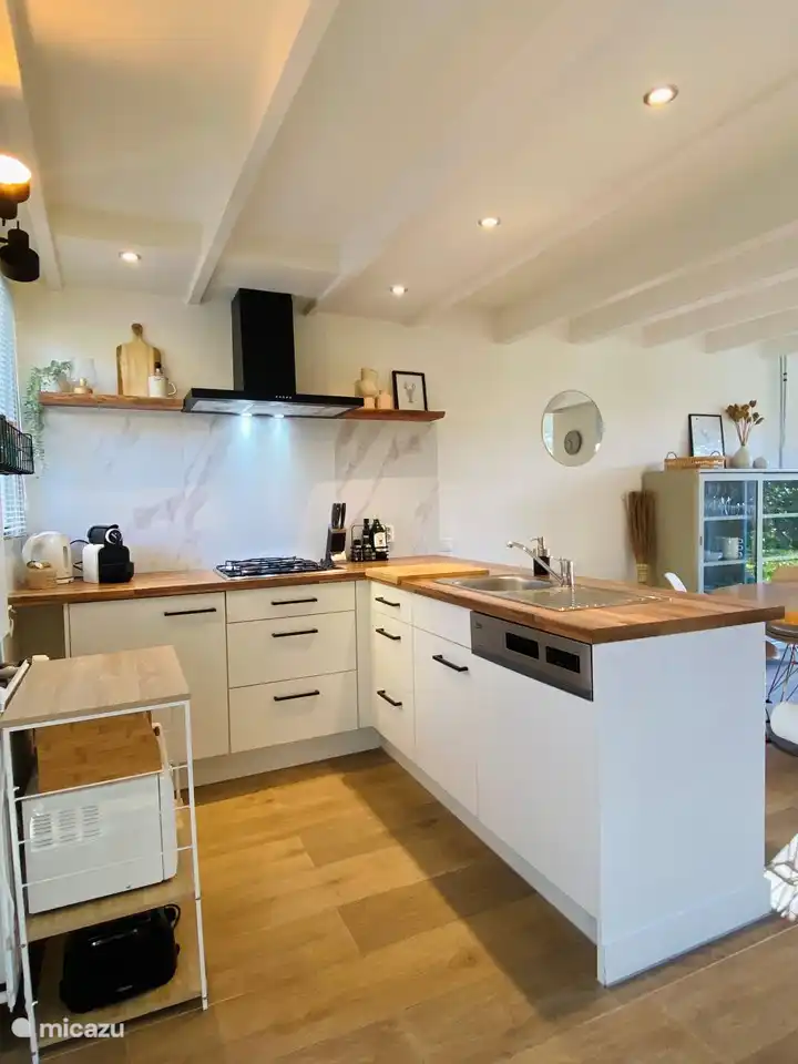 Küche mit Geschirrspüler, Backofen, Mikrowelle, Kühlschrank mit Gefrierfach, Espressomaschine (Filterkaffeemaschine auch vorhanden) und Wasserkocher.