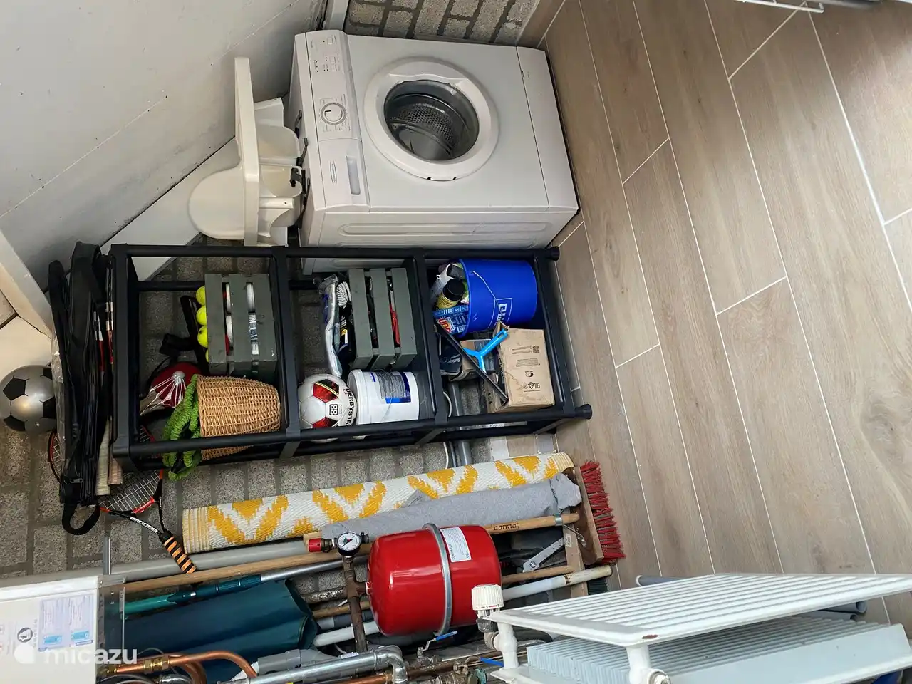 Abstellraum, Zugang über die Vorderseite des Hauses. Waschmaschine vorhanden. Sowie Tennisschläger, Tennisbälle, Hochstuhl, Staubsauger, Hängematte und der Sonnenschirm.