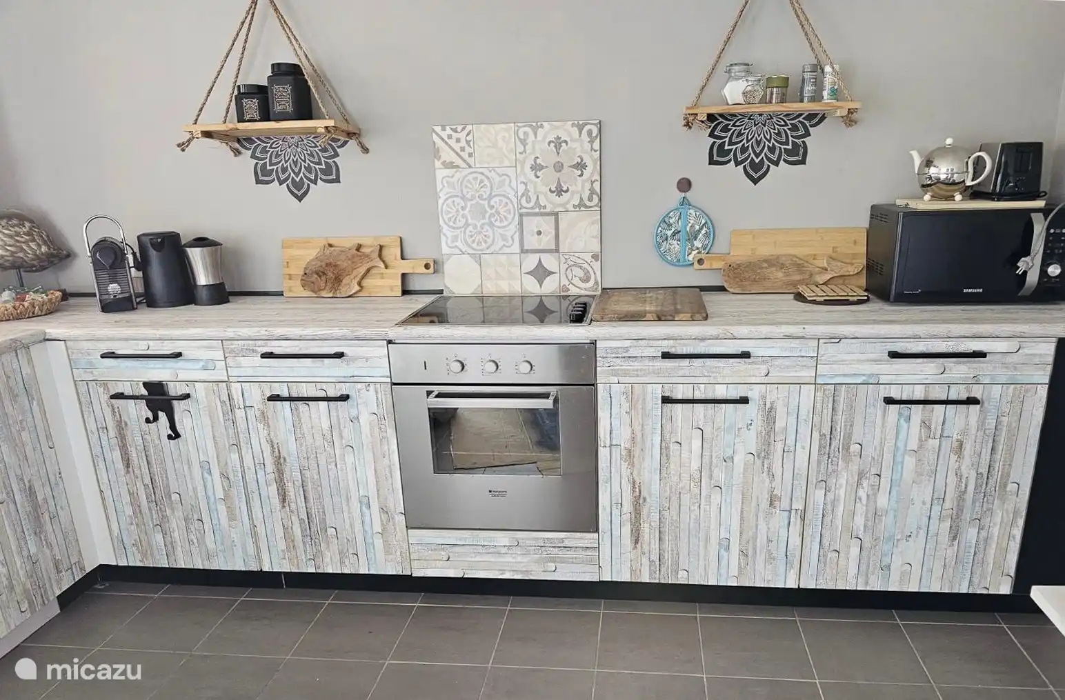 Cocina con horno, microondas, hervidor de agua, Nespresso, espumador de leche, lavavajillas, nevera con congelador y tostadora.