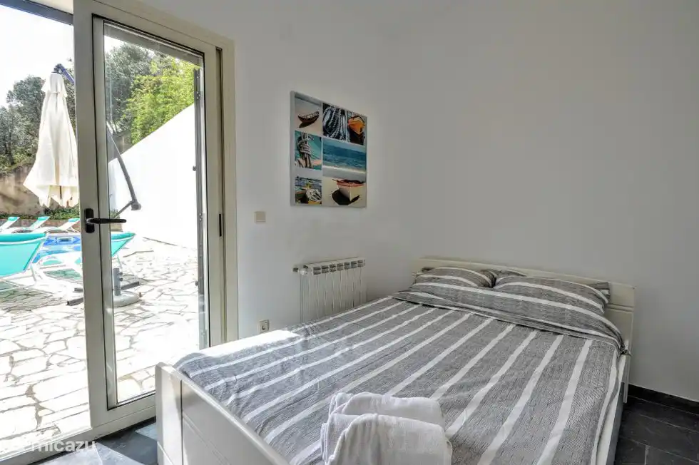 Chambre 3 avec un lit double et des portes coulissantes à la piscine.