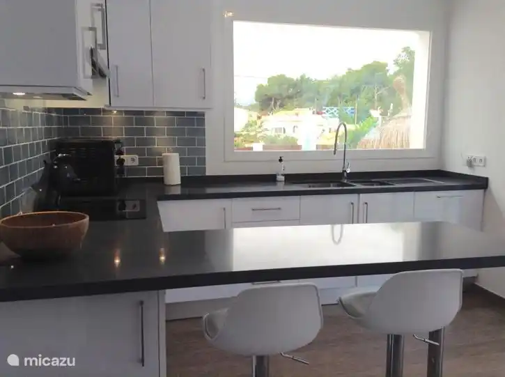 Moderne Küche komplett ausgestattet mit viel Licht.