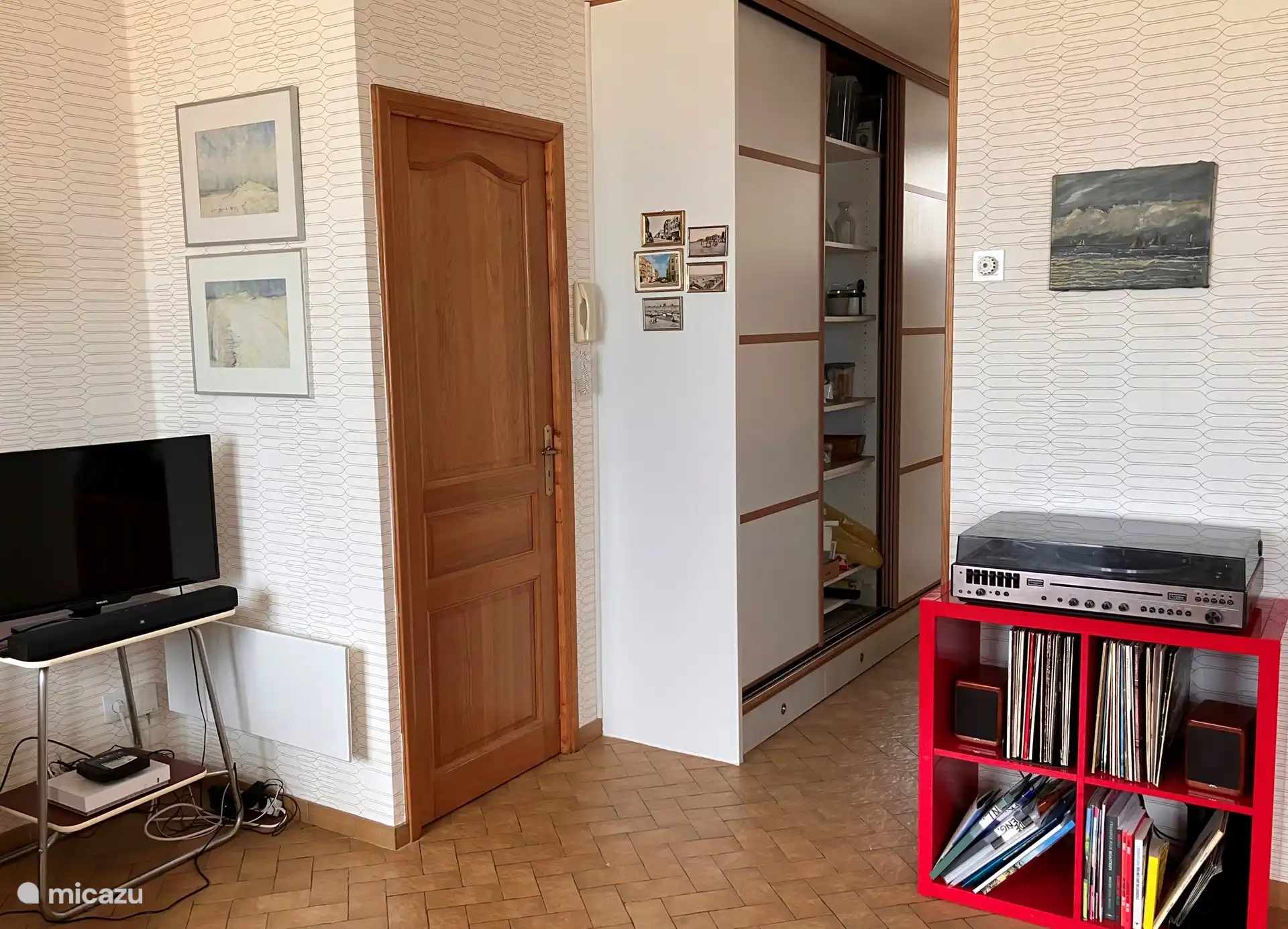 Le salon spacieux avec TV, internet et un tourne-disque confortable (avec des disques vinyles français) s’ouvre sur la cuisine et le hall où se trouvent les toilettes séparées. 