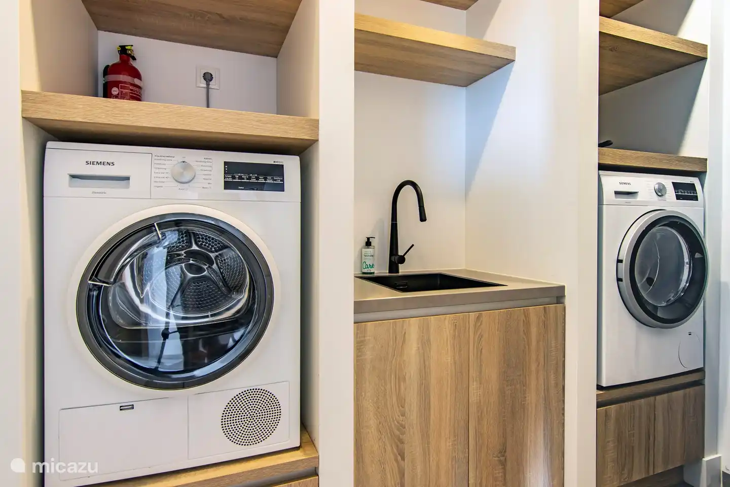 Buanderie avec lave-linge, sèche-linge et matériel de repassage.