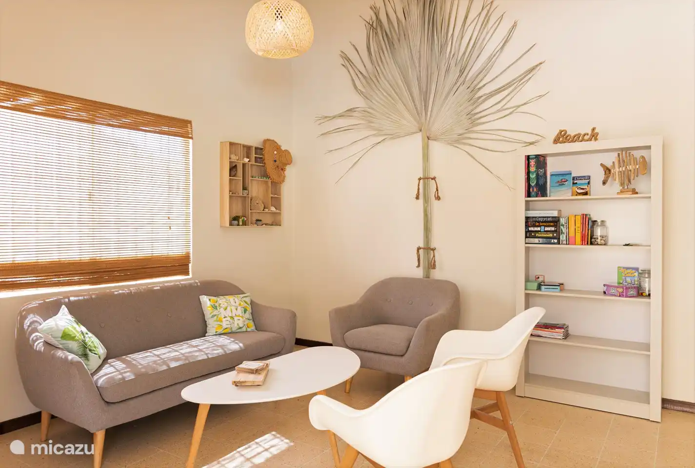 Décor naturel clair, couleurs calmes, placard rempli de livres, d’informations et de jeux