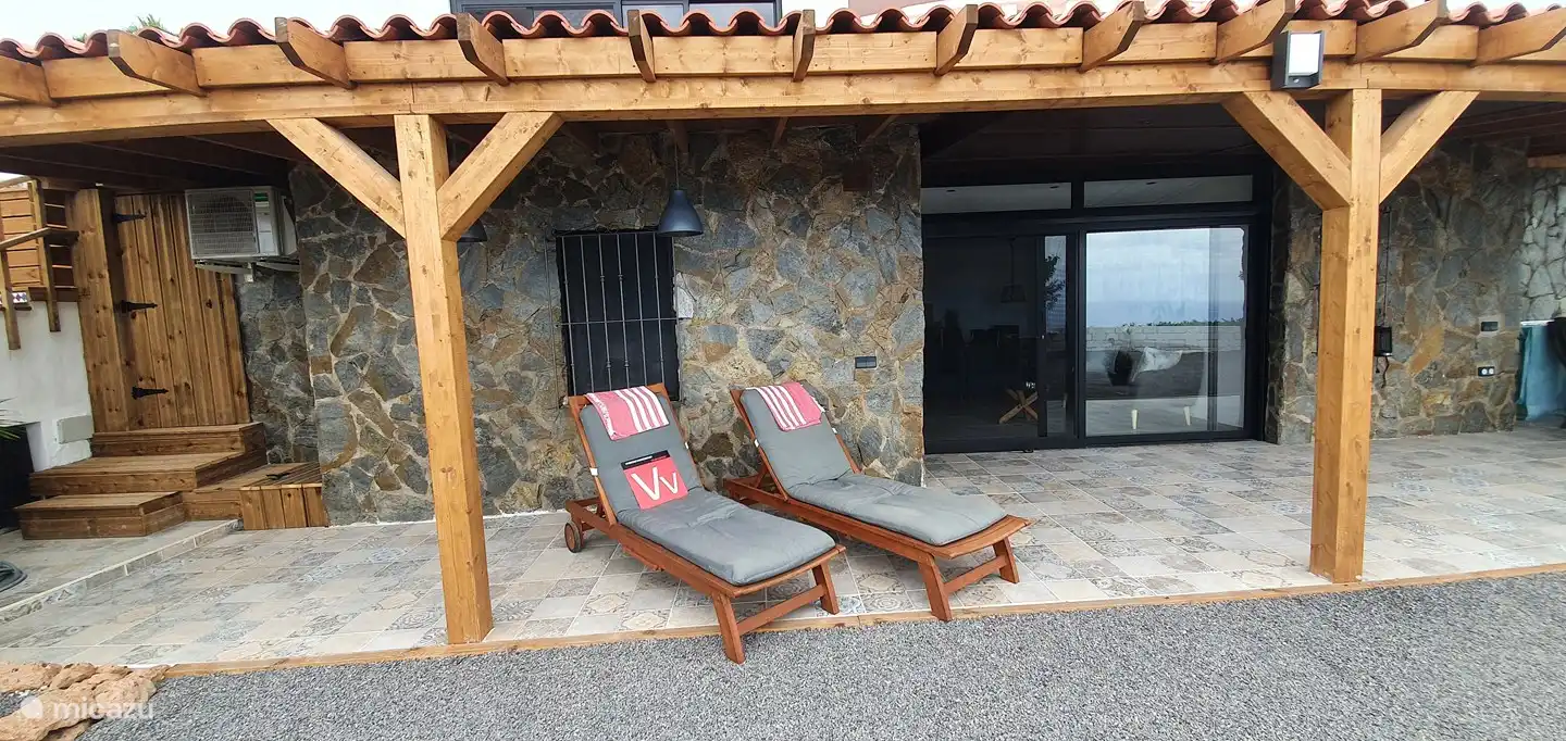 Porche avec chaises longues et notre enseigne indiquant que nous avons un permis de location,