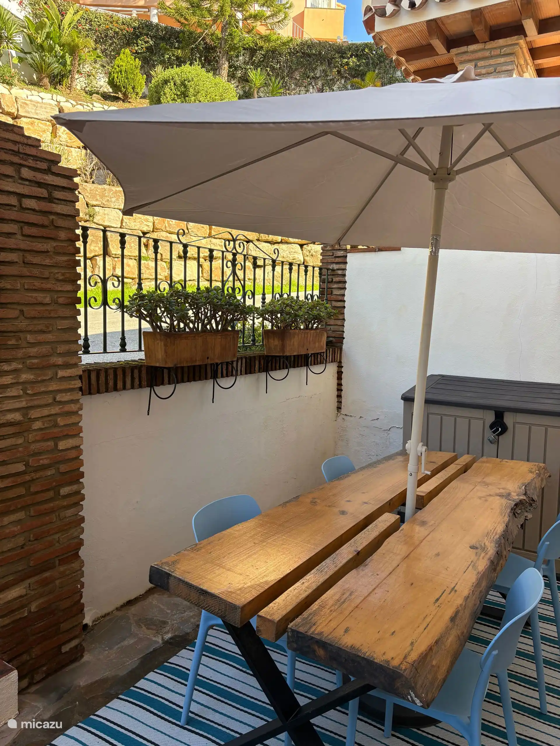 Terras met parasol aan de voorkant van het appartement