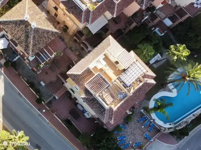 Location de Vacances Espagne, Costa del Sol, Mijas Golf, appartement - Casa Enviento Vue d'en haut : A seulement 15 mètres de la piscine. A gauche de la photo le parasol blanc de la terrasse à l'avant. A droite la piscine avec le jardin et les palmiers