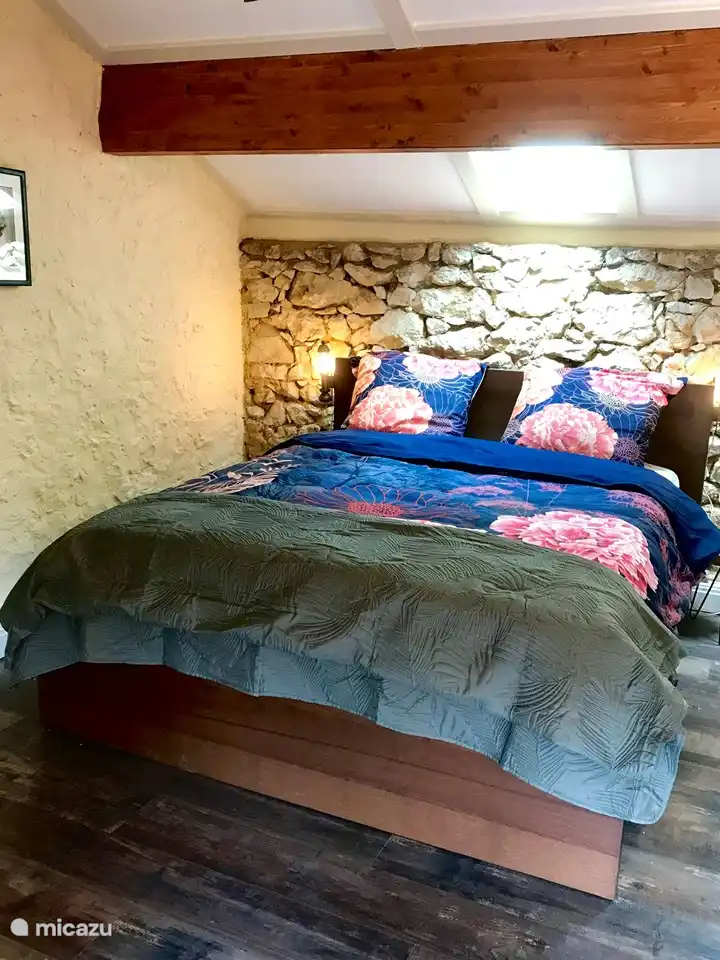 Un lit double 160x200 avec un ventilateur silencieux au-dessus.