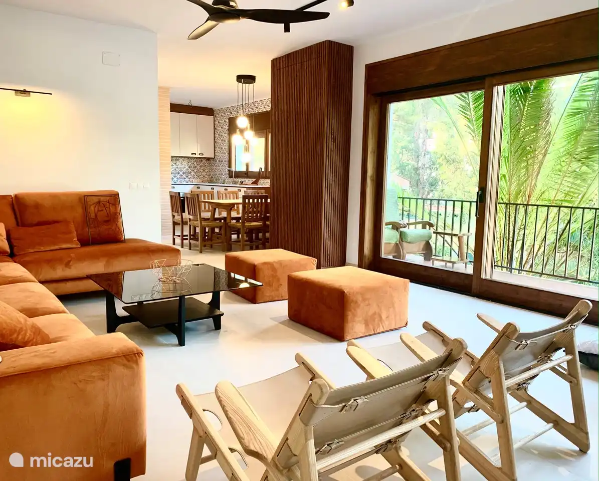 Das geräumige Wohnzimmer mit offener Küche und einem schönen freien Blick durch die großen Schiebefenster.