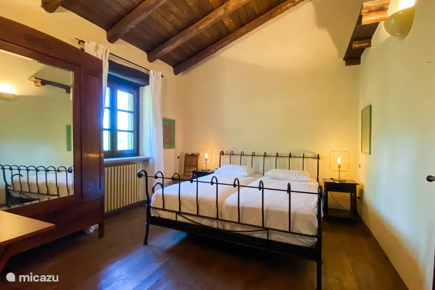 Das gelbe Zimmer mit einem Kingsize-Bett und neuen Matratzen und antikem Kleiderschrank, gegenüber dem Badezimmer.