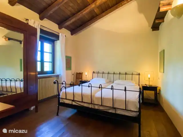 Casa Dolce Vista | Italie, Piémont, Monastero Bormida - maison de vacances La chambre jaune avec un lit king size et de nouveaux matelas et une armoire ancienne, en face de la salle de bain.