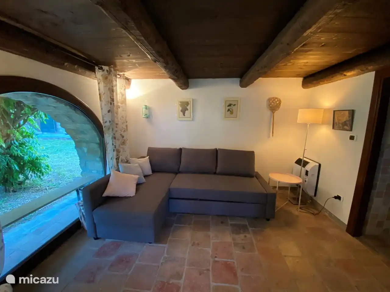 Das Erdgeschoss der Casina mit Lounge-Sofa und Badezimmer mit Dusche und WC.