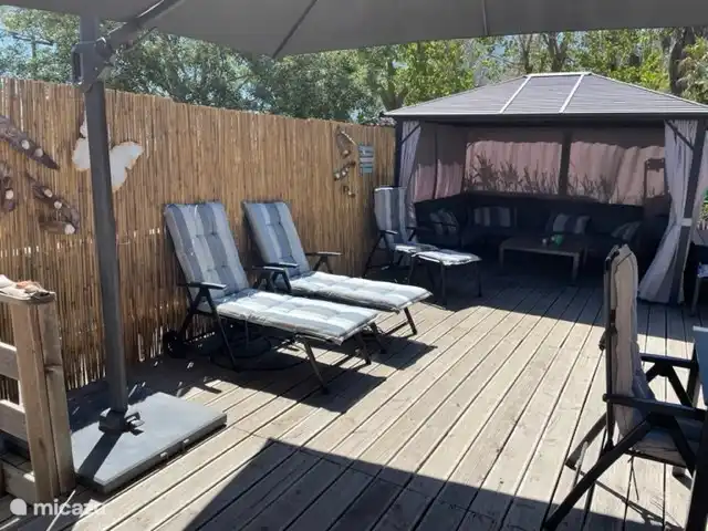 Schöne Terrasse, viele Stühle und Sonnenliegen