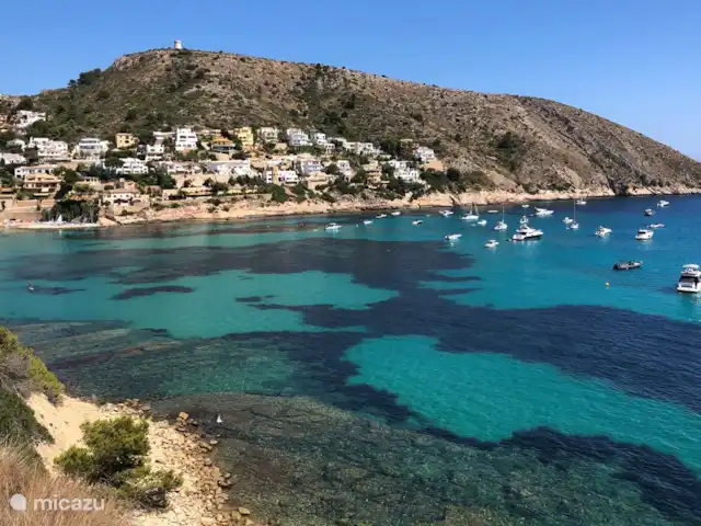 Casa Sueño | Espagne, Costa Blanca, Moraira - maison de vacances A gauche sur la photo : la jolie baie d'El Portet avec une plage de sable et des terrasses cosy. Sur la plage, vous pouvez louer des planches de SUP, des kayaks et des voiliers. À seulement 2,5 km de Casa Sueño.