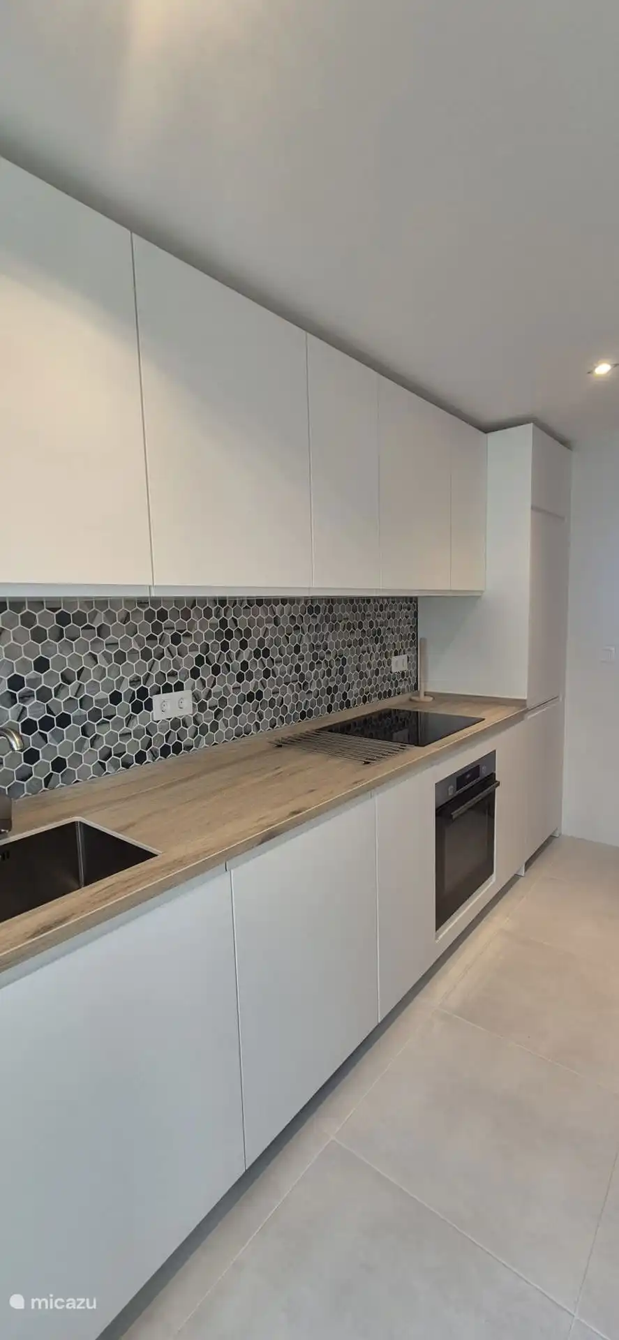 Cocina con lavavajillas, horno, vitrocer&#225;mica el&#233;ctrica y nevera.