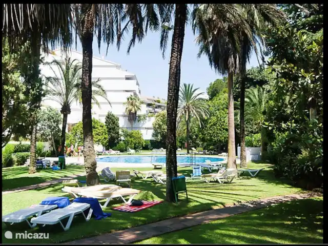Location de Vacances Espagne, Costa del Sol, Marbella, appartement - Casa Apolonia, Jardines del Mar Jardin magnifiquement envahi d'un complexe d'appartements avec piscine et chaises longues.
