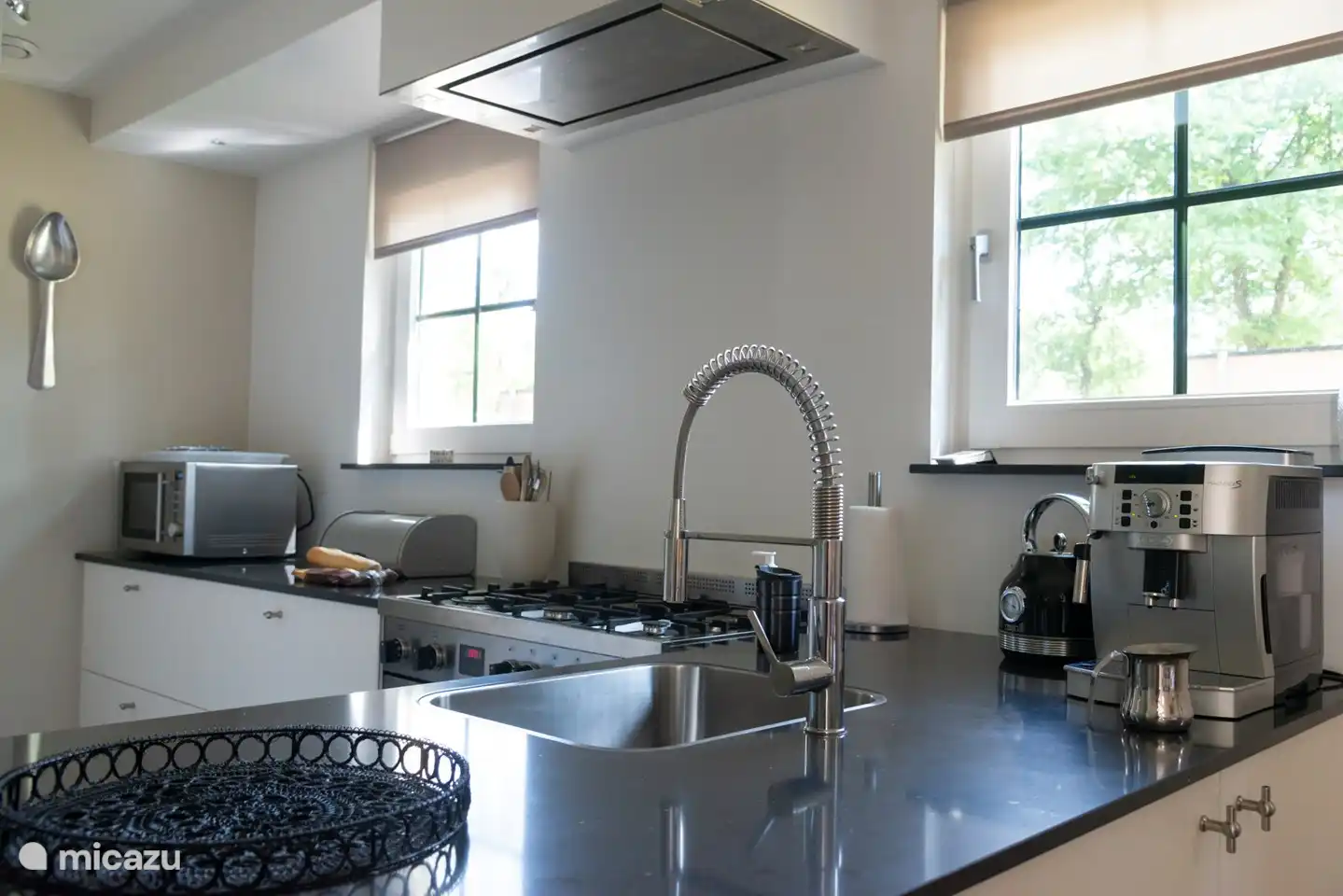 Offene Küche mit Mikrowelle, Wasserkocher und Delonghi-Kaffeemaschine.